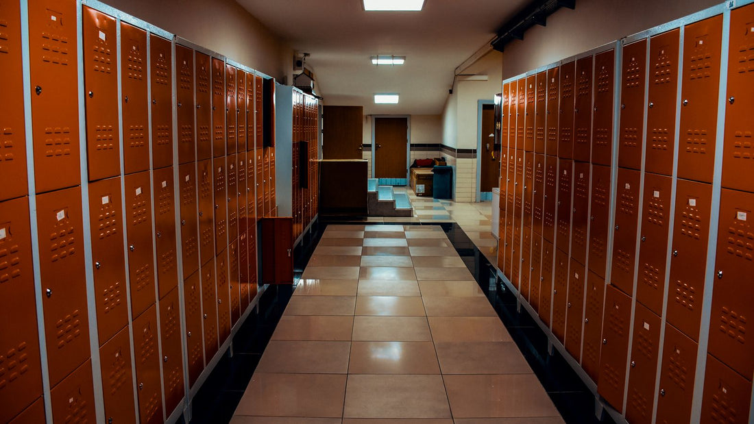 Empty locker room corridor with a tiled floor and wooden lockers, a common place to pick up athlete's foot