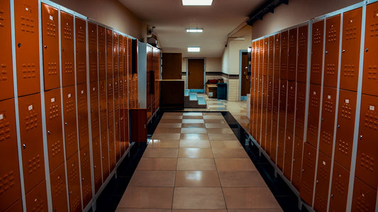 Empty locker room corridor with a tiled floor and wooden lockers, a common place to pick up athlete's foot