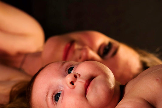 Mother lying face to face with her newborn in warm low light, the outcome behind questions about iodine deficiency and fertility