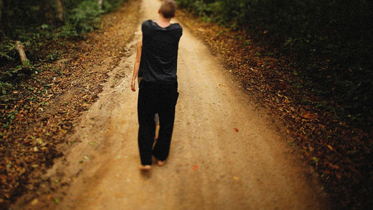 Person walking barefoot along a dirt path, illustrating an article about warts on feet and how to stop them coming back