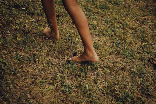 Smooth bare feet on grass, the soft skin result people want from a Baby Foot peel mask