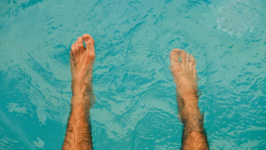 Bare feet dipped at the edge of a pool