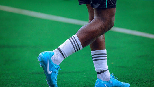 A player's legs and boots on the pitch