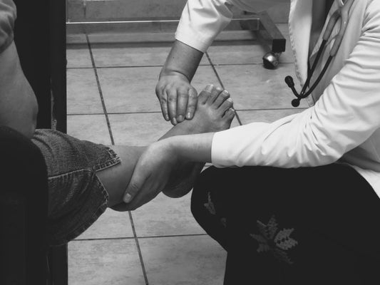 Foot care professional examining a patient's toenails before recommending a nail renewal product