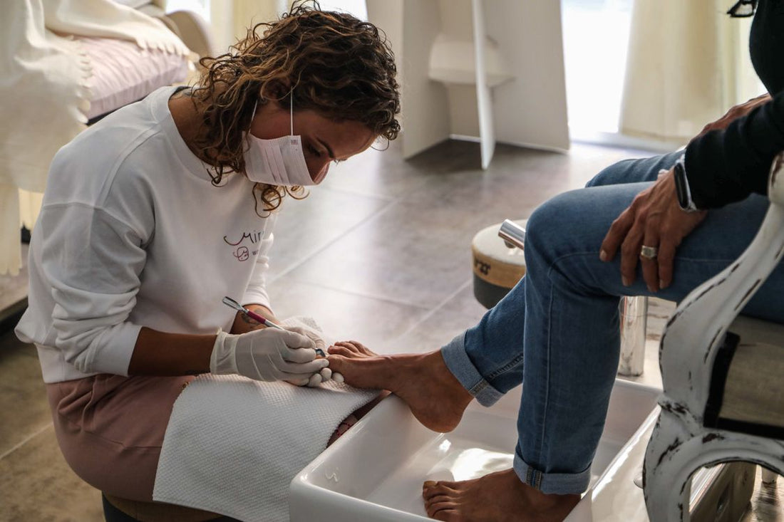 Foot-care professional treating a patient's foot during a clinic appointment