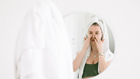 Person following a skincare routine at a bathroom mirror