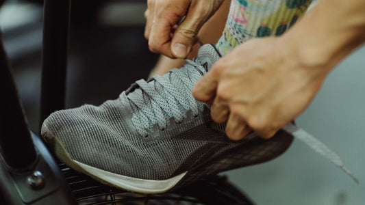 Hands tying the laces on a running shoe