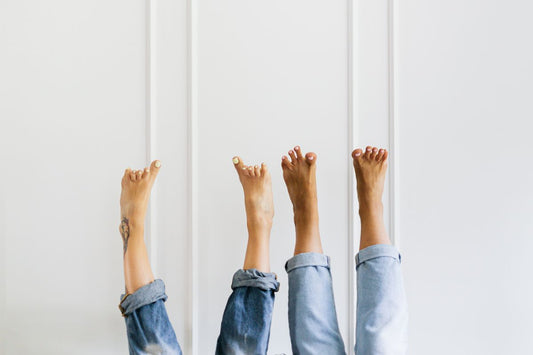 Bare feet raised against a wall, the at-home half of a routine run alongside prescription Jublia