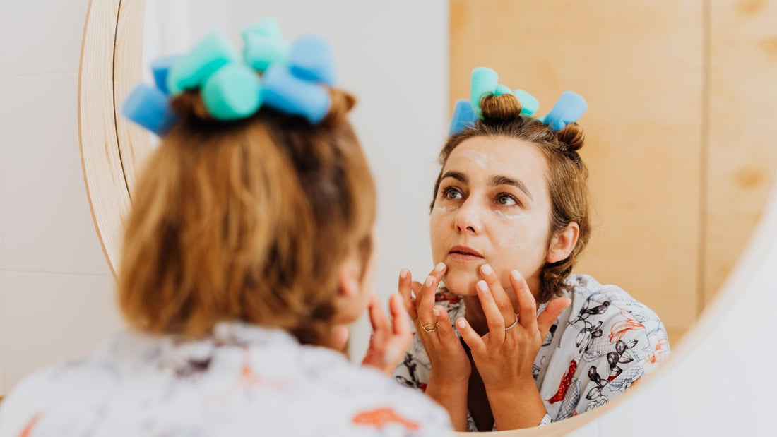 Person applying a cream at the bathroom mirror