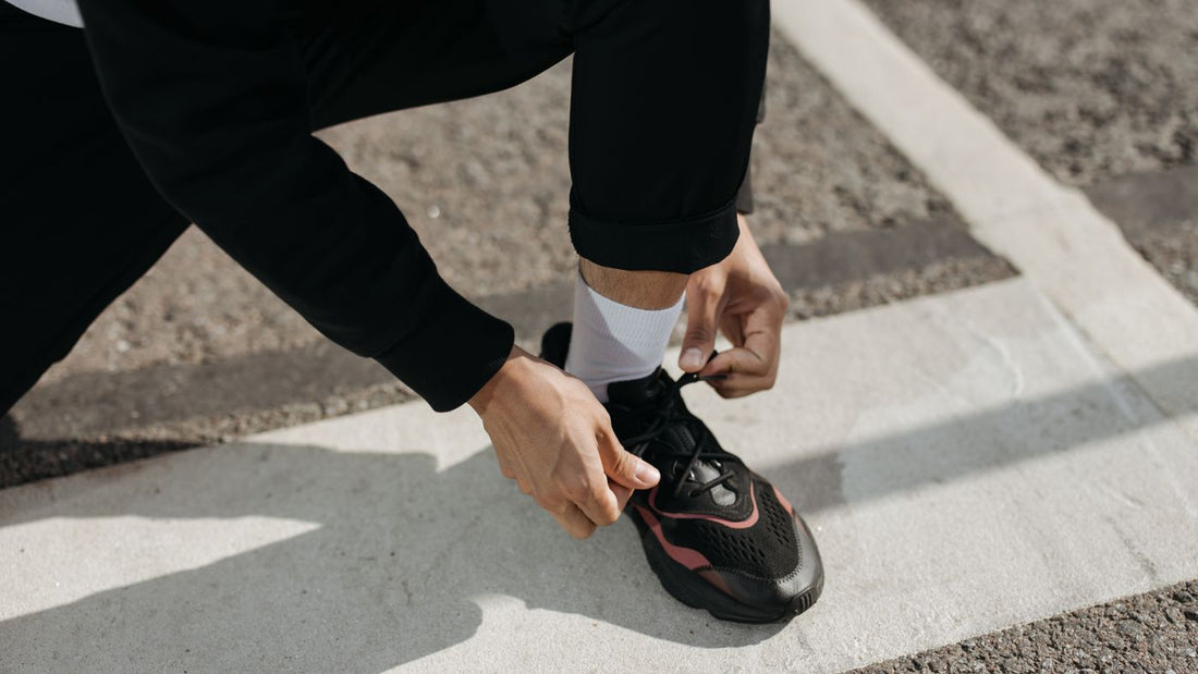 Person tying a trainer outdoors