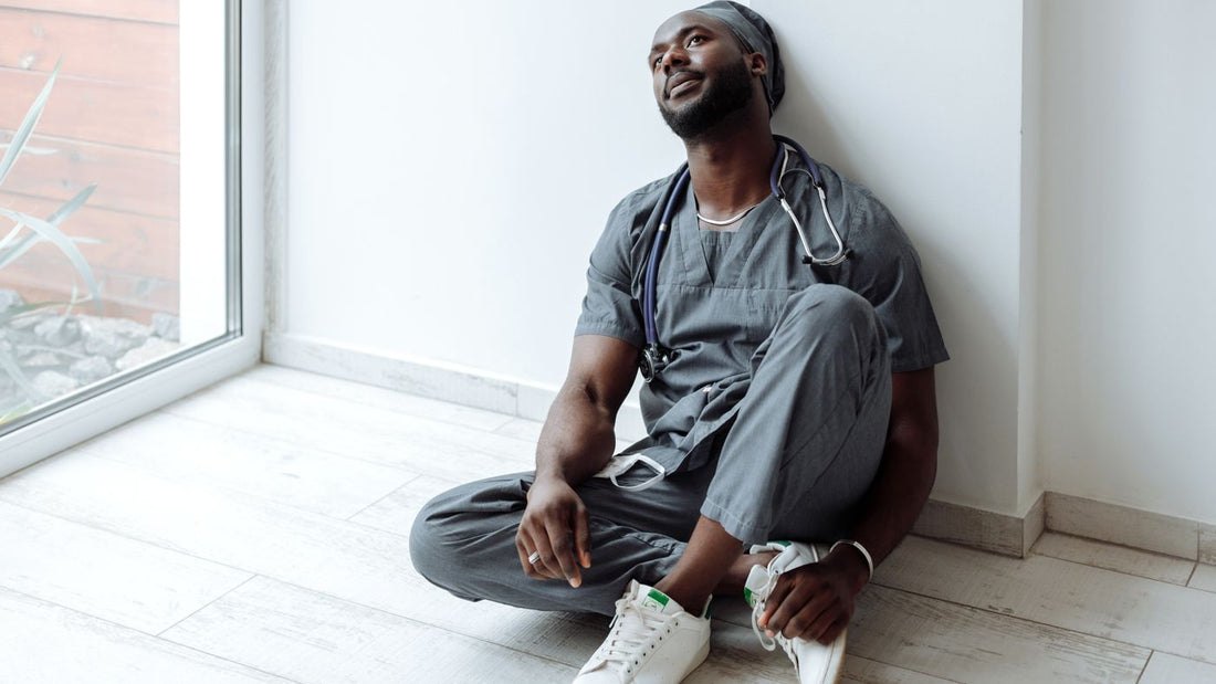 A healthcare professional in scrubs resting after a shift