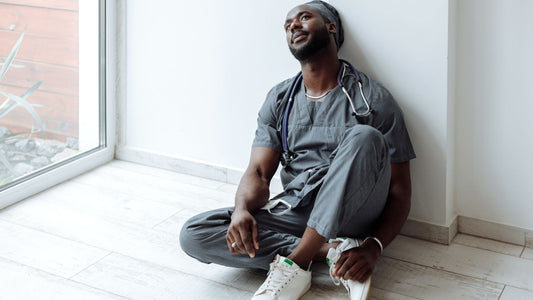 A healthcare professional in scrubs resting after a shift