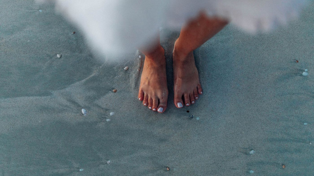 Bare feet on sand near the ocean