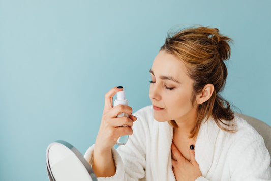 Person applying a spray mist as part of a skincare routine, the format shared by hypochlorous acid sprays and mineral alternatives