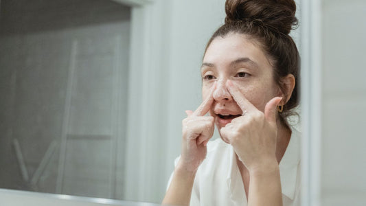 A teenager applying skincare at a bathroom mirror