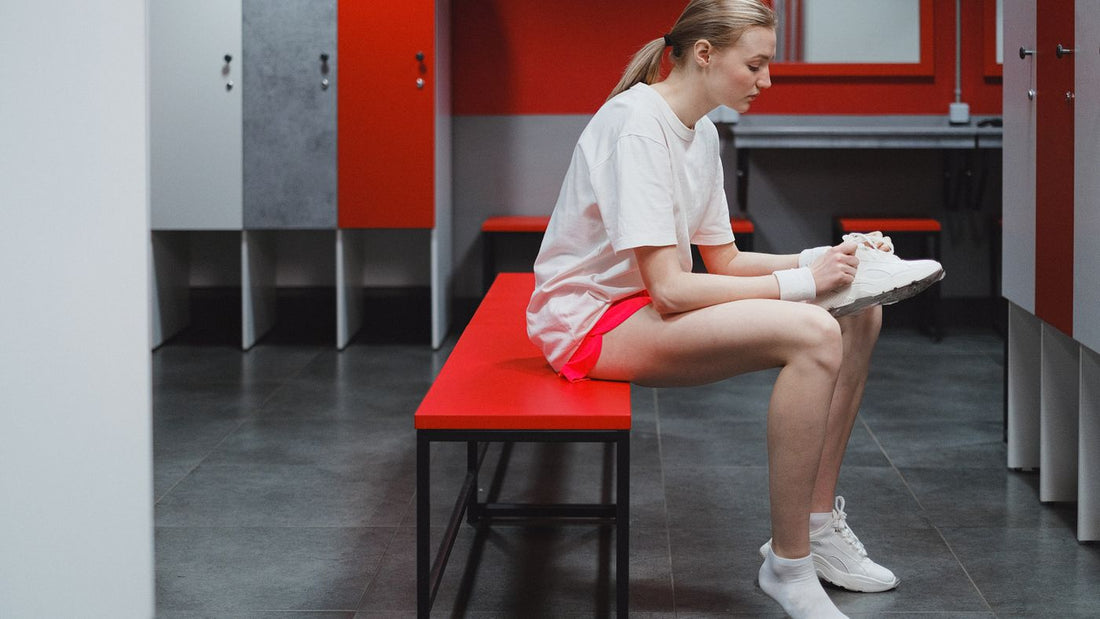 Person in a locker room lacing up work footwear