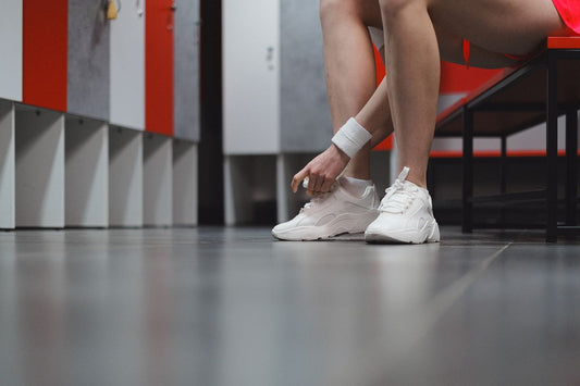 Bare feet going into trainers in a locker room, the footwear step a whole-body deodorant like Mando never treats