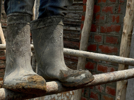 Muddy work boots worn through a full shift, the kind of enclosed footwear where shoe odor builds up