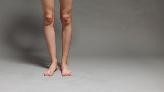 Lower legs and bare feet on a plain grey background