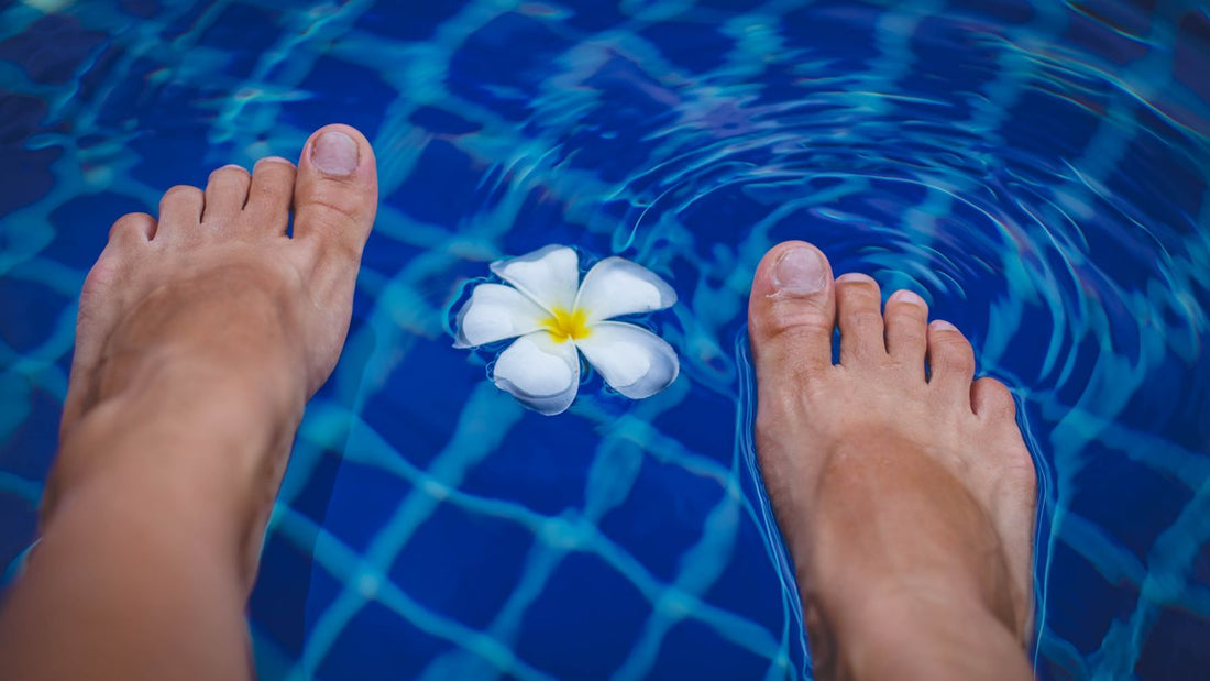 Bare feet at the edge of a clear blue pool