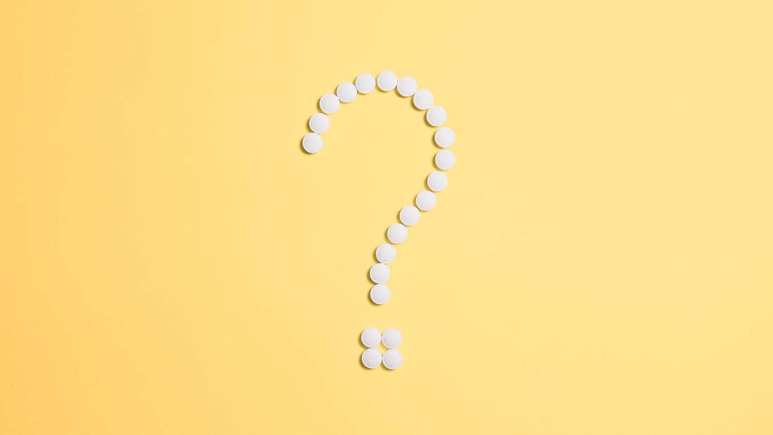 White pills arranged in the shape of a question mark, illustrating a comparison of Jublia and IodinePure for toenail fungus