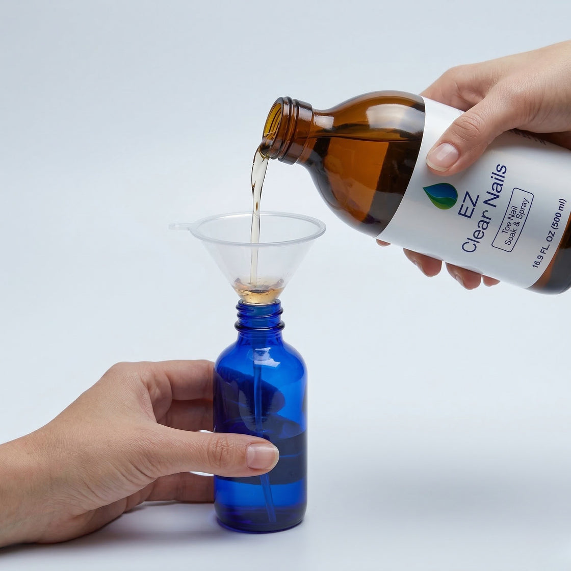 Filling the 30ml spray bottle from the 500ml EZ Clear Nails solution using the funnel